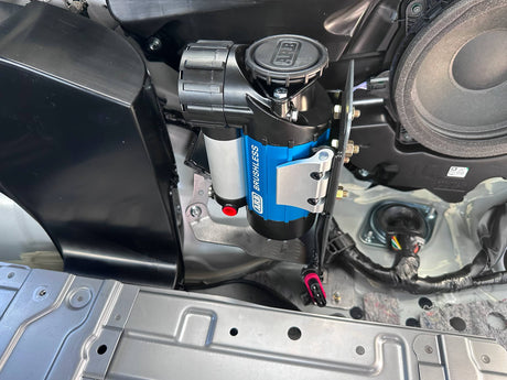 Blue and black air compressor mounted inside a vehicle's open compartment