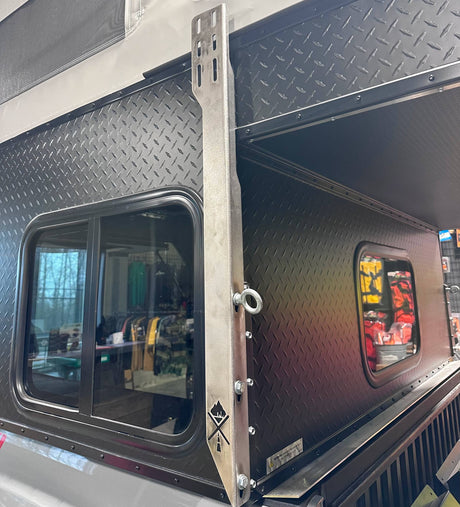 Metal awning bracket on black Project M camper