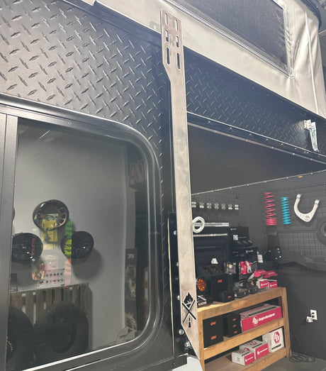 Metal awning bracket on black Project M camper