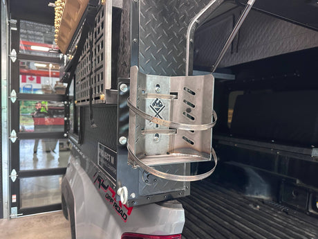 Propane bracket mounted to the back of a truck bed camper.