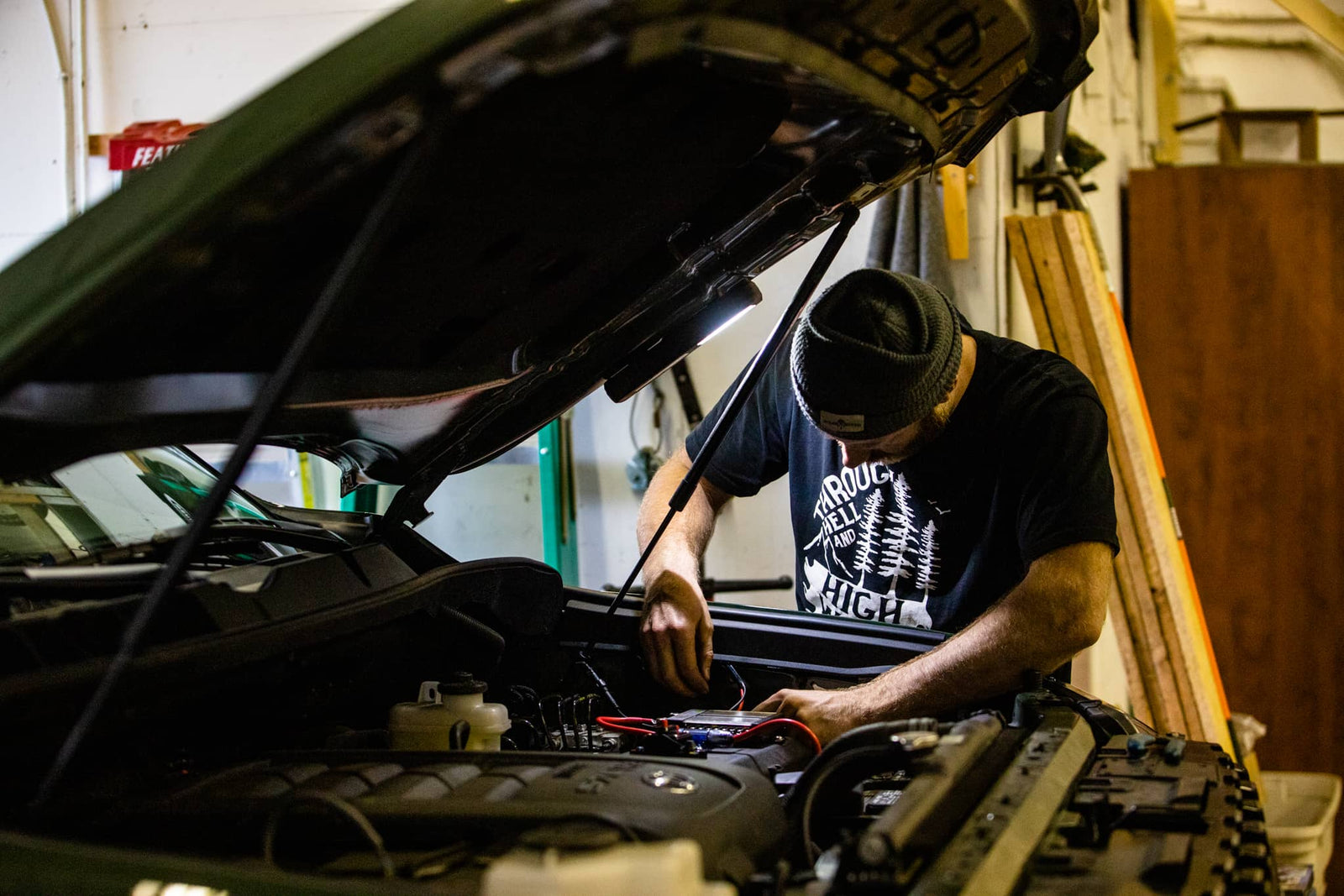 Person working on a car engine in a garage