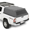 White truck with a black roof rack and gray tonneau cover on a white background