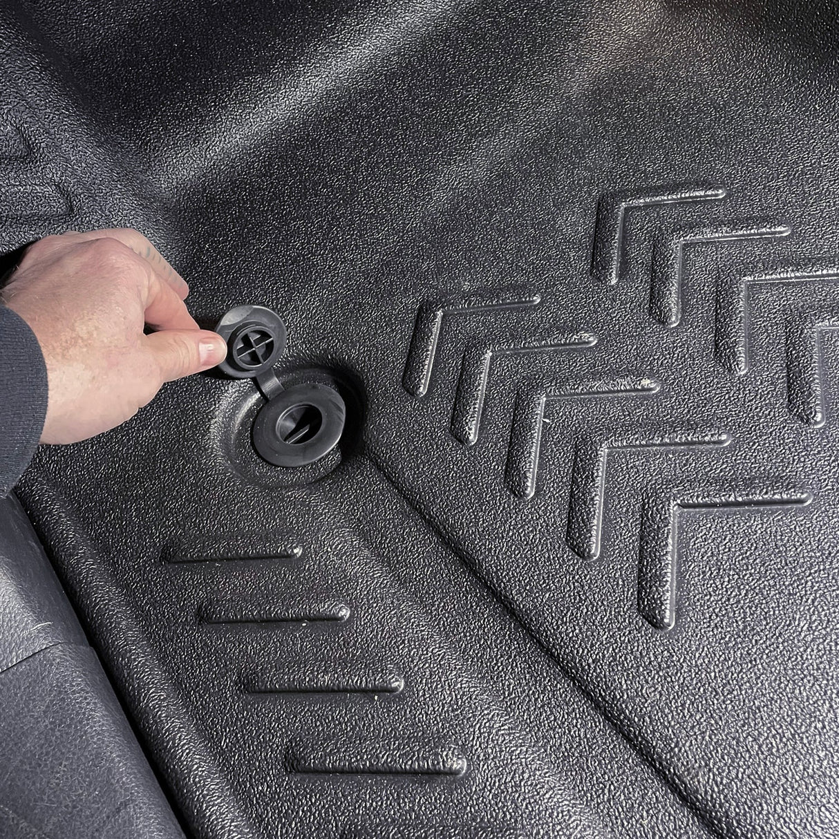 Close up image of floor drain being opened on driver side 