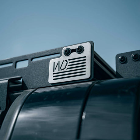 License plate holder with a logo on a vehicle against a blue sky