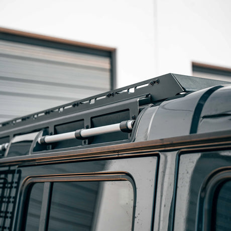 Close-up of a vehicle roof rack system on a truck with a blurred background.