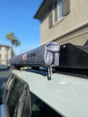 Roof rack with a gray cover on a car, brand 'Alpine' visible