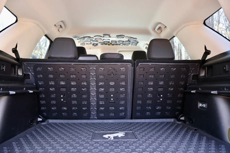 Car interior with a black cargo mat covering the floor.