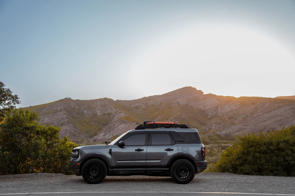 SUV parked on a road with mountains in the background
