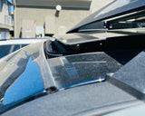 Close-up of a car's open sunroof with a building in the background